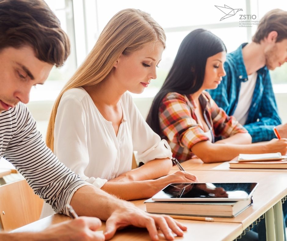 grupa uczniów siedzi przy stole
