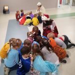 grupa dzieci siedzi na podłodze i czyta książki