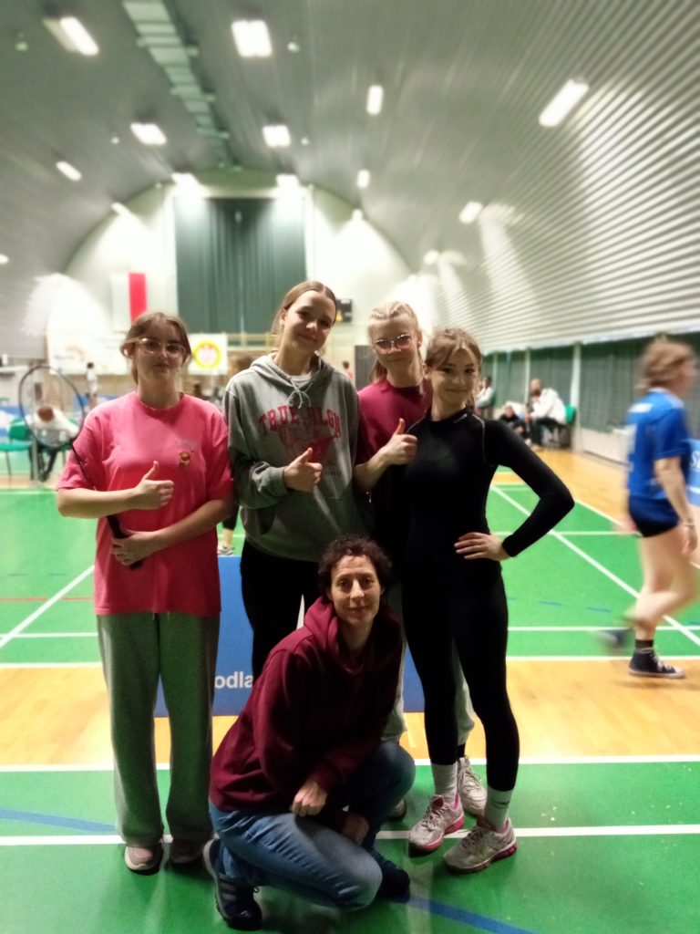 grupa dziewczyn pozuje do zdjecia, stroje sportowe, w tle hala sportowa