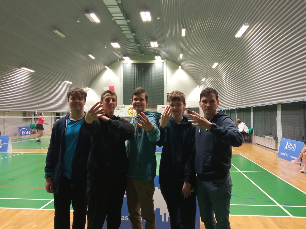 grupa chłopców pozuje do zdjecia, stroje sportowe, w tle hala sportowa