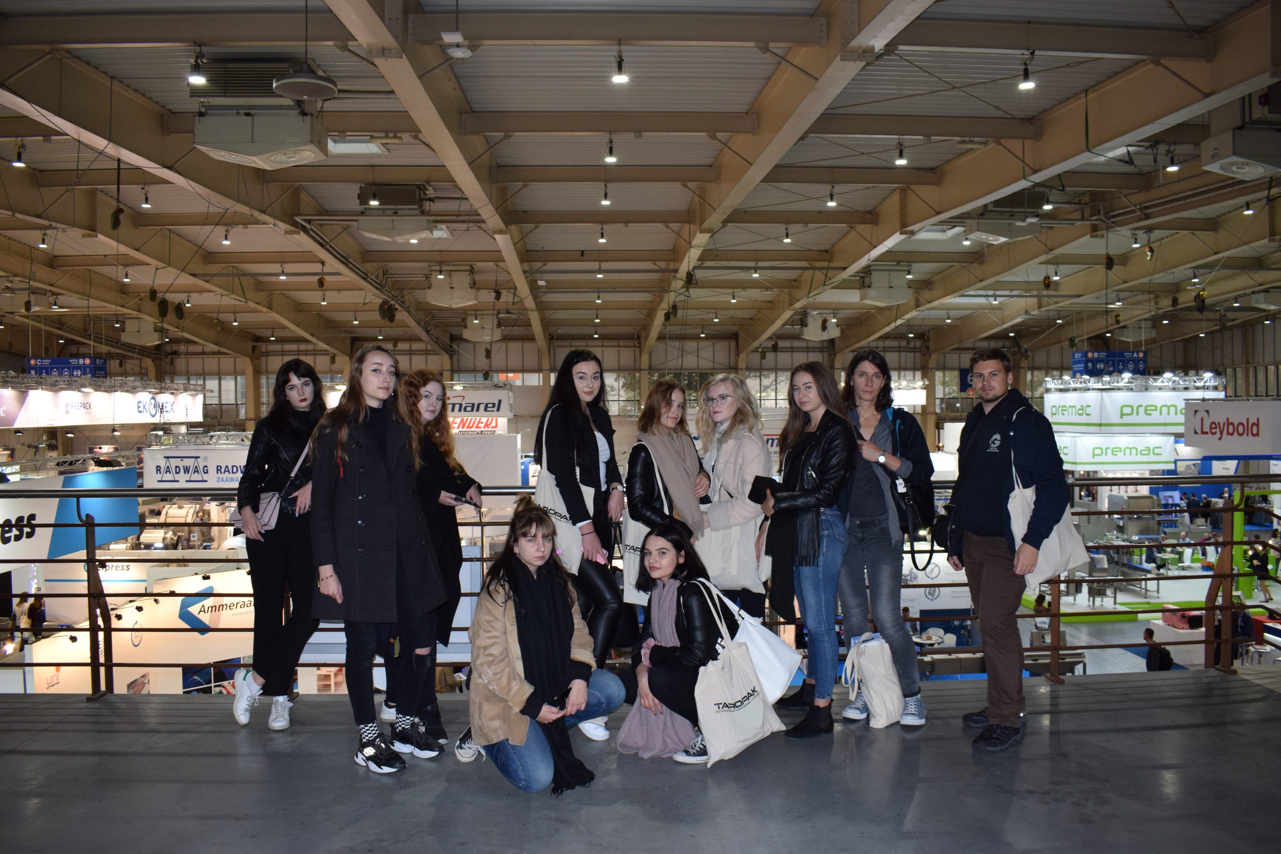 grupa ludzi na pseudowidokowym tarasie wewnątrze hali