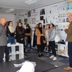 grupa ludzi na tle ściany z wydrukami