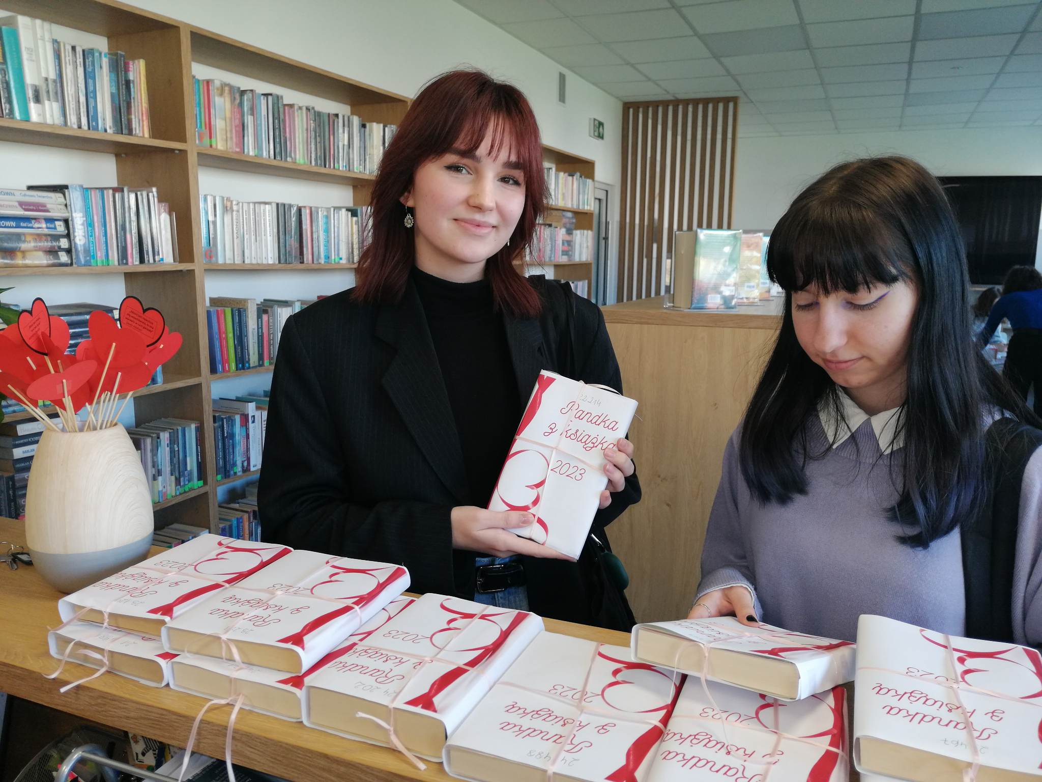 dwie młode dziewczyny trzymają w rękach książki