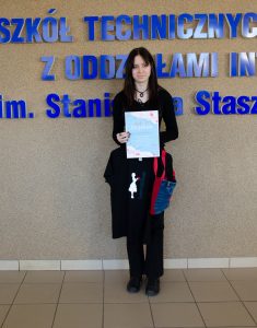 młoda dziewczyna, uczennica, trzyma dyplom i koszulkę