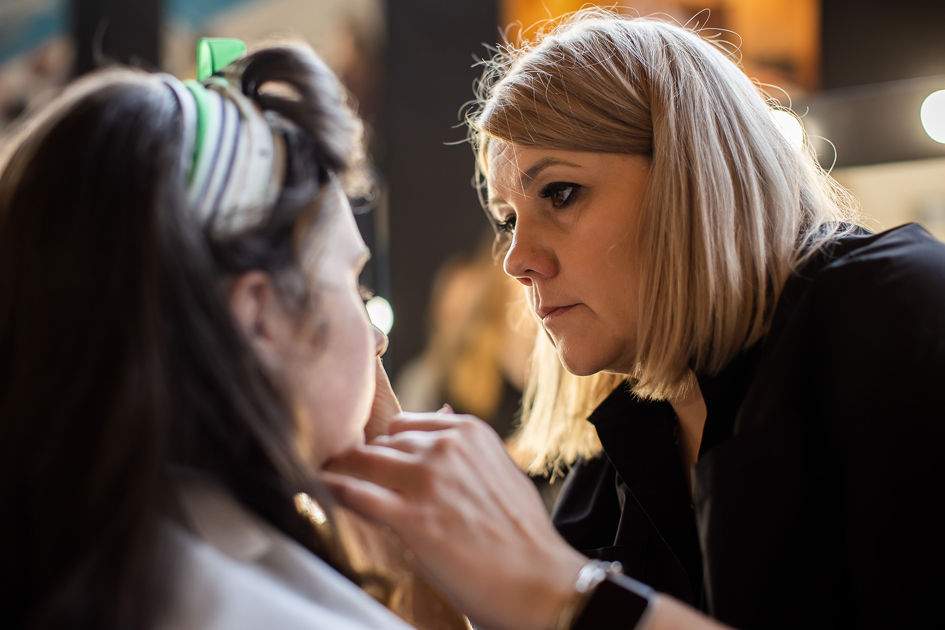 kobieta blondynka maluje twarz dziewczyny