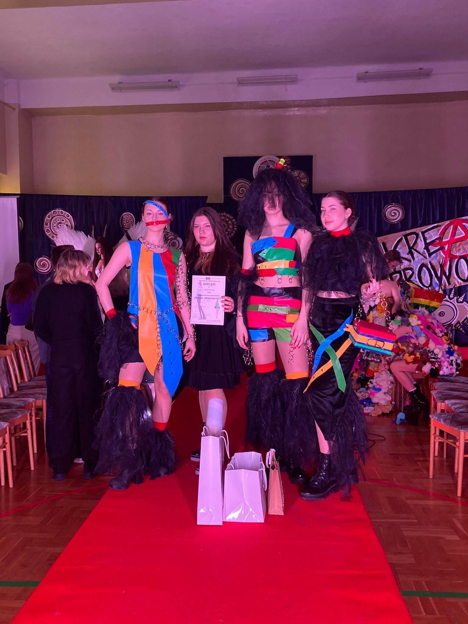 grupa dziewczyn pozuje do zdjecia, ubrane w kolorowe stroje