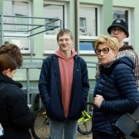 grupa uczniów stoi na podwórku, z lewej nauczyciel