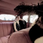 uczennica szkoły siedząca na tylnej kanapie w samochodzie z okresu lat 20 XX w.